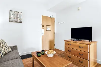 a living room with a couch and a tv on a dresser at Serene 1BR Retreat with Mountain Views in Canmore