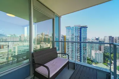 a balcony with a bench and a view of a city at Gorgeous Water View Unit in Downtown Vancouver in Vancouver