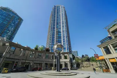 a tall building with a clock in the middle of a street at Gorgeous Water View Unit in Downtown Vancouver in Vancouver