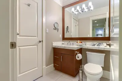 a bathroom with a toilet and a sink and a mirror at 3Bed 2Bath Steam Sauna Retreat! Family friendly! in Vancouver