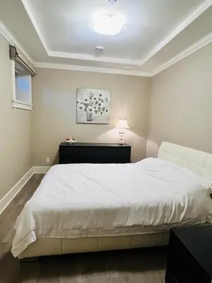 a bedroom with a white bed and a white couch at 3Bed 2Bath Steam Sauna Retreat! Family friendly! in Vancouver