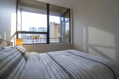 a bedroom with a bed and a large window at Beautiful Downtown Unit in Vancouver