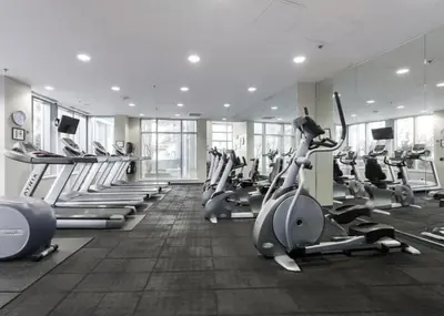 a gym with rows of exercise bikes and treadmills at Bright 3BR Downtown Vancouver Condo w Pool & Gym in Vancouver