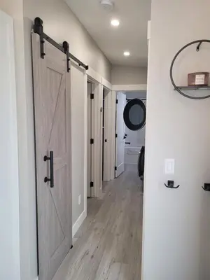 a hallway with a sliding barn door in a house at Creekside Oasis on Mara in Sicamous