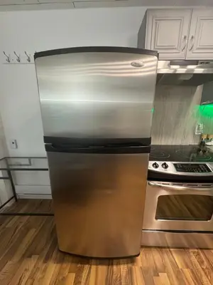 a stainless steel refrigerator in a kitchen next to a stove at Sasha-Home 538 Brookmere Ave in Coquitlam