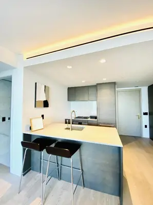 a kitchen with a sink and a counter with stools at Brand New Luxury 1 bedroom Condo in Downtown Vancouver in Vancouver