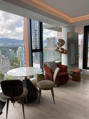 a living room with a table and chairs and a large window at Brand New Modern 2 BR Condo in Heart of Downtown Vancouver in Vancouver