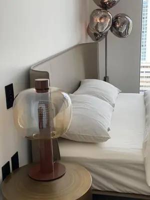 a bedroom with a bed and a table with a lamp at Brand New Modern 2 BR Condo in Heart of Downtown Vancouver in Vancouver