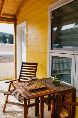 a wooden table and a chair on a porch at Abraham - Peaceful cabin in historic Nordegg in Nordegg