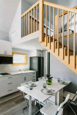 a kitchen and dining room with a white table and chairs at Abraham - Peaceful cabin in historic Nordegg in Nordegg