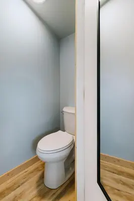 a bathroom with a white toilet in a room at Adventure Knap Shack in Nordegg
