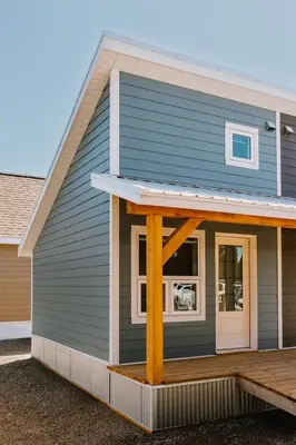 a blue house with a porch and a window at Adventure Knap Shack in Nordegg