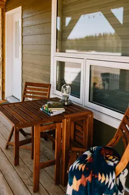 a wooden table and a chair on a porch at Baldy- Modern tiny home in historic Nordegg in Nordegg