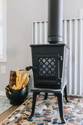 a black stove sitting on a rug in a room at Coliseum - Get Back to Nature in Nordegg