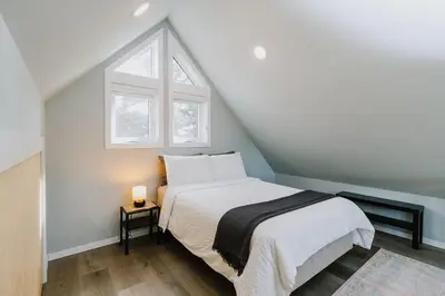 a bedroom with a white bed with a window at Coliseum - Get Back to Nature in Nordegg