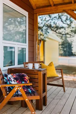 a porch with a table and chairs and a window at Eagle - Cozy tiny home with mountain views in Nordegg