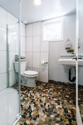 a bathroom with a toilet and a sink and a shower at Eagle - Cozy tiny home with mountain views in Nordegg