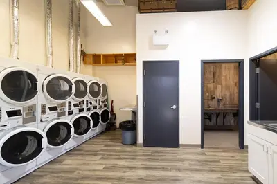a laundry room with four washers and a black door at Trailhead Tuck-Inn in Nordegg