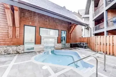 a hot tub in the middle of a patio at Chic Rockies Getaway - Pool & Hot Tub - King Bed - BBQ! in Canmore