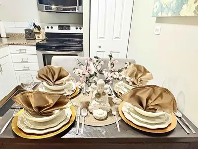 a table with plates and dishes on it in a kitchen at Stylish Downtown Condo near Rogers Place l Parking, Gym, Balcony & Kitchen in Edmonton