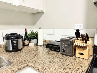 a kitchen counter top with a toaster and a toaster and a knife block at Stylish Downtown Condo near Rogers Place l Parking, Gym, Balcony & Kitchen in Edmonton