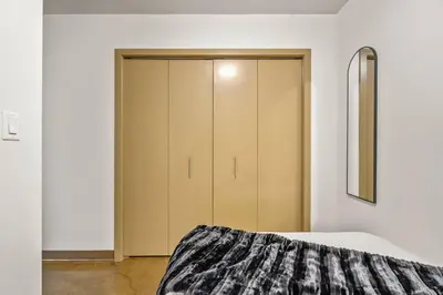 a bedroom with a bed and a closet at The Prime Downtown | Luxe Condo + Free Parking in Calgary