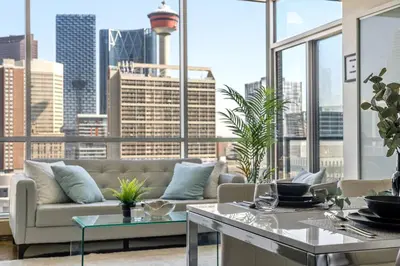 a living room with a couch and a large window at The Prime Downtown | Luxe Condo + Free Parking in Calgary