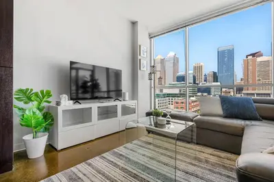 a living room with a couch and a large window at Downtown Chic Retreat | Elegant + Free Parking in Calgary