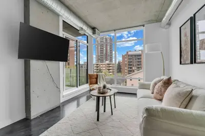 a living room with a couch and a tv at Stylish Beltline 1BR w/ Parking in Calgary