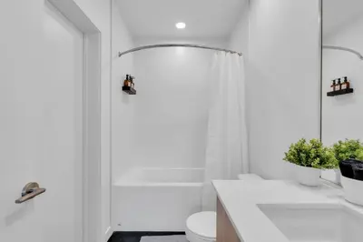 a bathroom with a shower and a toilet and a sink at Stylish Beltline 1BR w/ Parking in Calgary
