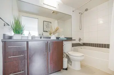 a bathroom with a sink and a toilet and a tub at Executive Unit with Spectacular Views in Vancouver
