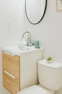 a bathroom with a sink and a toilet and a mirror at Naramata Courtyard Suites in Naramata