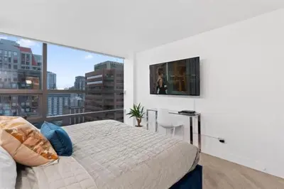 a bedroom with a bed and a view of a city at Executive Downtown Suite with Great City Views in Vancouver