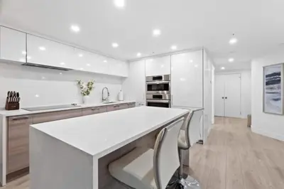 a white kitchen with a large white counter top at Executive Downtown Suite with Great City Views in Vancouver