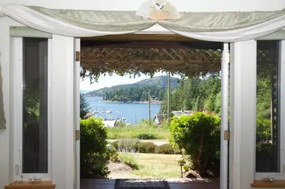 an open door to a house with a view of the water at Enchanter Ocean View Suites in Madeira Park