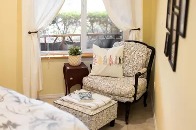 a bedroom with a chair and a window at Enchanter Ocean View Suites in Madeira Park
