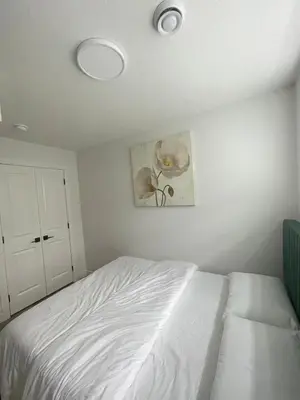 a bedroom with a white bed and a flower picture at Your Cozy Happy Place in Calgary
