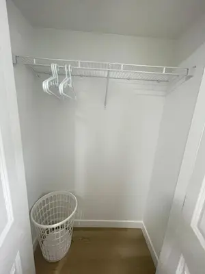 a white closet with a basket in a room at Your Cozy Happy Place in Calgary