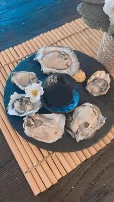 a plate of oysters and flowers on a table at Victoria's Family Oceanside Retreat, brand new 2br basement in Colwood