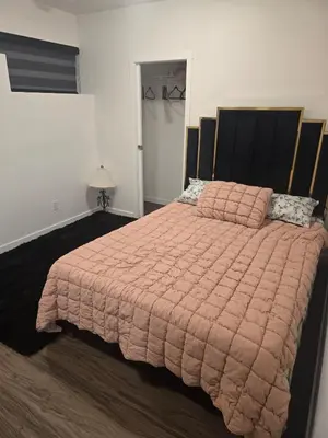 a bedroom with a large bed with a pink comforter at Cozy 2-Bedroom Suite 5 Minutes Walk to Chestermere Lake in Chestermere