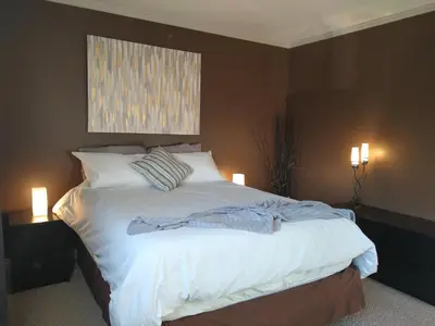 a bedroom with a large bed with white sheets and pillows at Condo Unit-UofA, UofA Hospital, Whyte Ave, Trails! in Edmonton