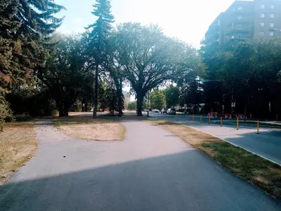 a walking path in a park with trees and buildings at Condo Unit-UofA, UofA Hospital, Whyte Ave, Trails! in Edmonton