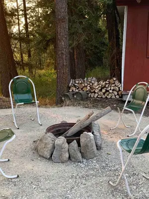 two chairs and a fire pit with two baseball bats at Entire Cordwood House 5 minutes south of town in Golden