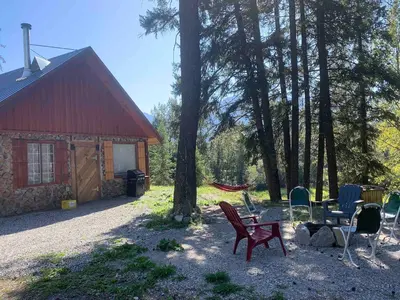 a group of chairs and a table in front of a cabin at Entire Cordwood House 5 minutes south of town in Golden