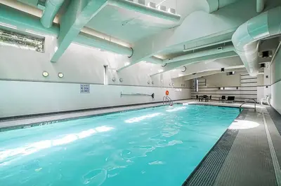 a large indoor swimming pool with blue water at Gorgeous Unit with Beautiful City Views in Vancouver