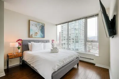 a bedroom with a large bed and a large window at Gorgeous Unit with Beautiful City Views in Vancouver