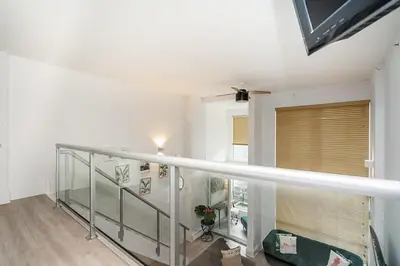 a staircase with a glass railing and a window at Trendy Loft in Downtown in Vancouver