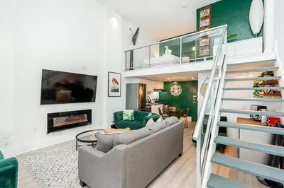 a living room with a couch and a staircase at Trendy Loft in Downtown in Vancouver