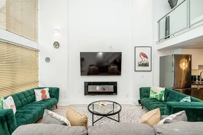 a living room with green couches and a tv at Trendy Loft in Downtown in Vancouver
