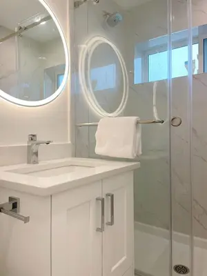 a white bathroom with a sink and a shower at A Beautiful, cozy second floor room for staying in Vancouver